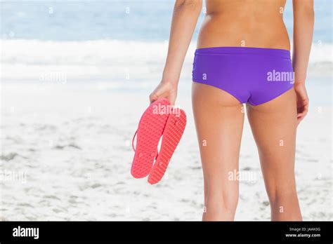 Woman In Bikini On Beach Holding Flip Flops Standing Back To Camera Stock Photo Alamy