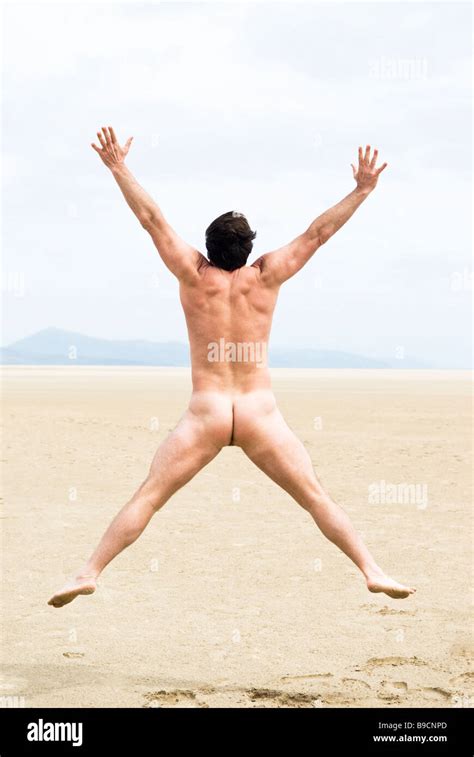 A Naked Fit Forties Man Is Jumping For Joy On A Beautiful Sandy Beach On The Island Of