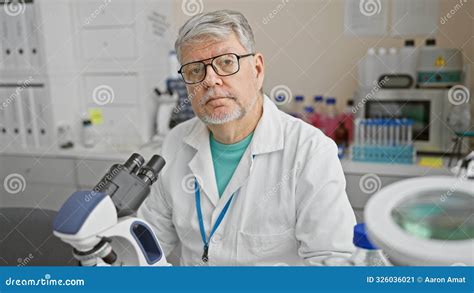 Mature Man In Lab Coat With Microscope In A Laboratory Setting Stock
