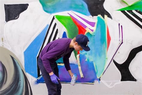 premium photo young man painting graffiti  wall