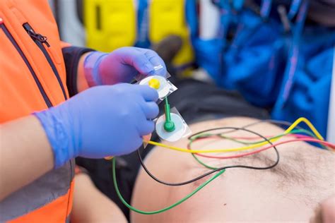 Manos De Un Médico De Urgencias Colocando Electrodos De Ecg En El Pecho Del Paciente En