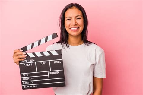 Joven Latina Sosteniendo Claqueta Aislada Sobre Fondo Rosa Feliz Sonriente Y Alegre Foto Premium