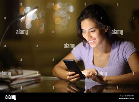 Happy Woman In The Night Using Cell Phone At Home Stock Photo Alamy