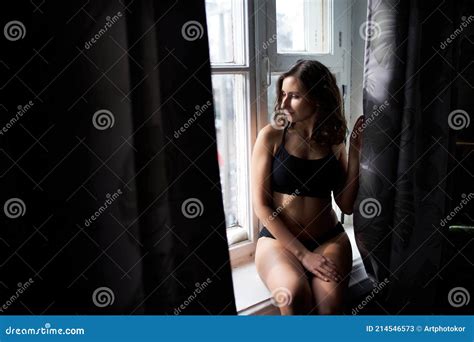 A Naked Beautiful Busty Girl Sits On The Windowsill And Looks Out The Window Advertising