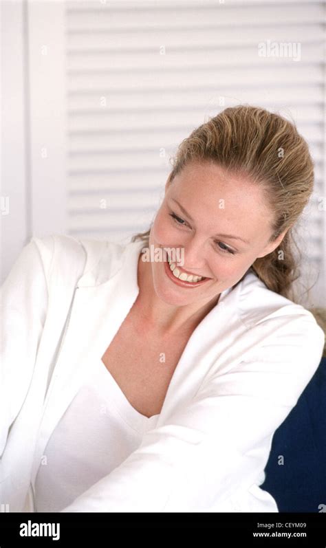 Female Long Wavy Blonde Hair In Ponytail Wearing Subtle Make Up White Vest Top Under White