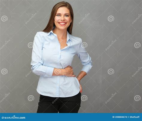 Smiling Business Woman Wearing Blue Shirt Standing In Front Of Grey