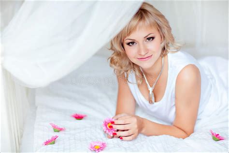 Fille Blonde Mignonne Dans Une Robe Lumineuse Se Trouvant Sur Un Sofa Blanc Photo Stock Image