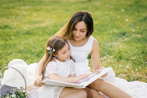 Mãe e filha felizes da família estão assistindo a um álbum fotos no