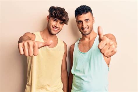 Jovem Casal Gay Usando Roupas Casuais Aprovando Fazer Gestos Positivos Polegares Para Cima