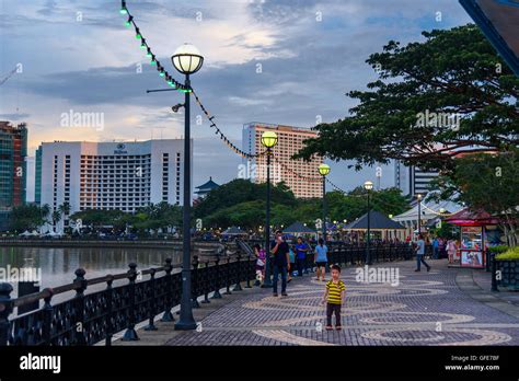 Kuching City Waterfront At Sunset People Walk On The Street Sarawak