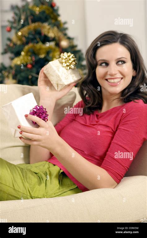 Female With Brunette Wavy Hair Wearing Bright Pink Top Lime Green Silk Trousers Sitting On