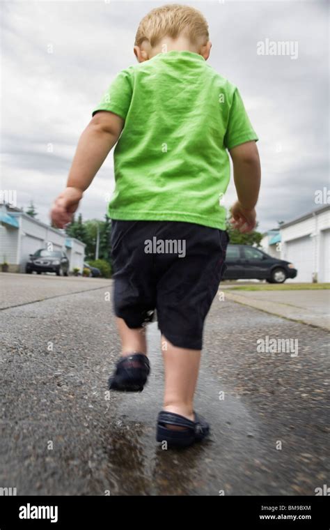 Boy Walking In A Puddle Stock Photo Alamy