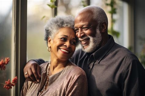 Casal de idosos afro americanos saudáveis sorrindo felizes e abraçando