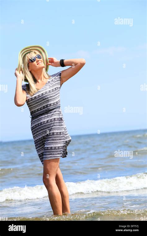 Full Length Mature Woman With Hat On Beach Enjoying Summer Holiday Stock Photo Alamy