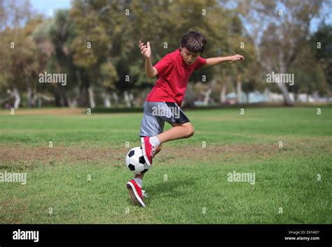 Niño juega con una pelota de fútbol practicando patadas acción