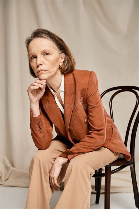Mature Woman In Tan Suit Seated Stock Photo Image Of Confident Business