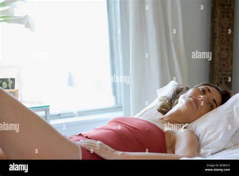 Mature Woman Lying On A Bed Stock Photo Alamy