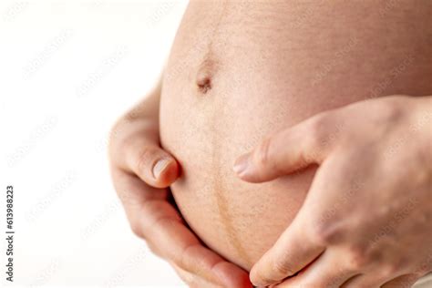 Pregnant Woman Gently Holding Her Naked Round Belly With Her Hands In Final Month Of Pregnancy