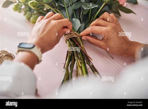 Qualified Florist Tying A Brown Thread Around A Bunch Of Flowers Stock