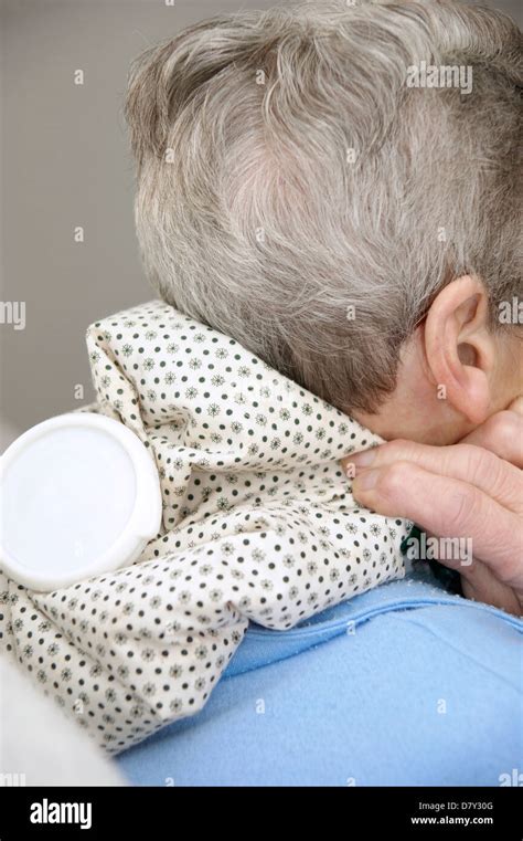 Elderly Woman Using A Hot Water Bottle For Neck Shoulder Pain Stock Photo Alamy