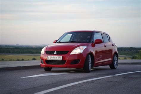 red suzuki swift   road  stock photo