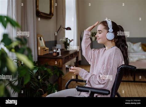 Young Girl Listening Music Trough Headphones In Her Room Stock Photo