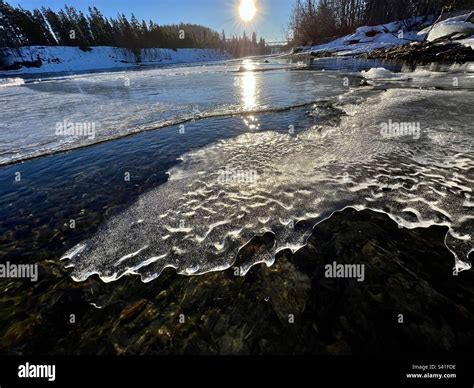 Semi-transparent ice sheet on Yukon River, reflecting sunlight and with ...