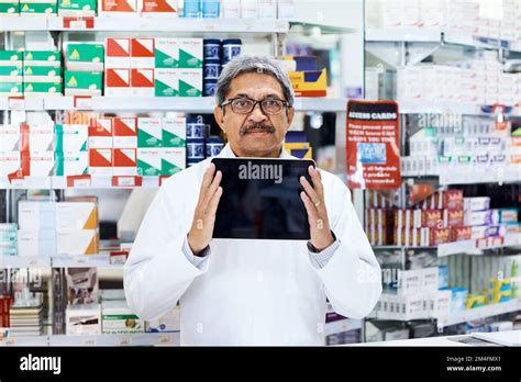 Heres ma recommandation principale Portrait d un pharmacien mature tenant un comprimé numérique