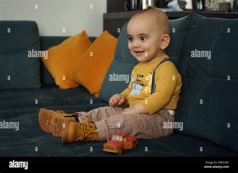 Adorable kid smiling and sitting on couch Stock Photo - Alamy