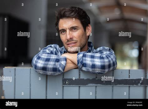 Handsome Farmer Leaning In Barn On Tractor Wheel Stock Photo Alamy