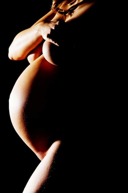 Premium Photo Midsection Of Naked Pregnant Woman Standing Against Black Background