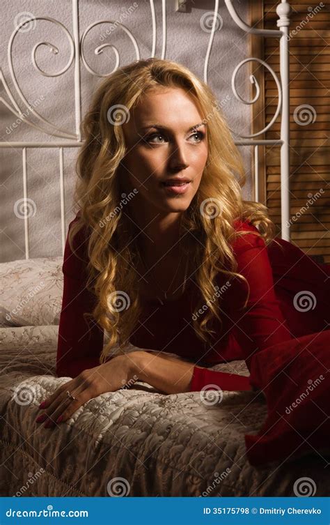Blonde Sensual En Un Vestido Rojo Que Miente En La Cama Foto De Archivo Imagen De Relaje