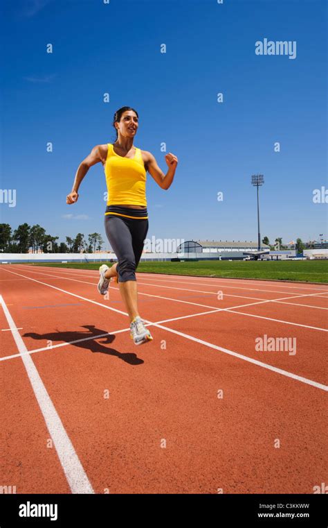 Female athlete sprinting at stadium Stock Photo - Alamy