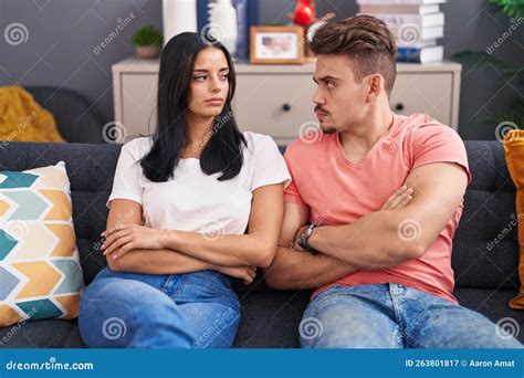 Man And Woman Couple In Disagreement Sitting On Sofa At Home Stock