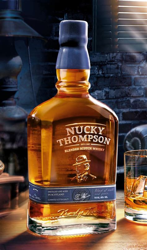 a bottle of whisky sitting on top of a wooden table next to a glass ...