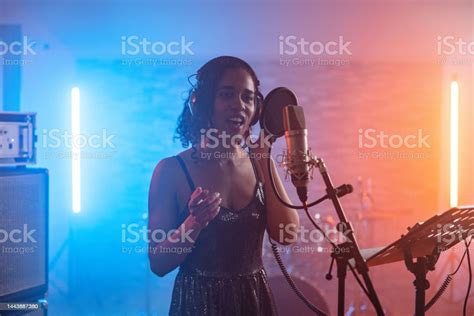 Young Adult Black Female Singer With Curly Hair Passionately Singing In