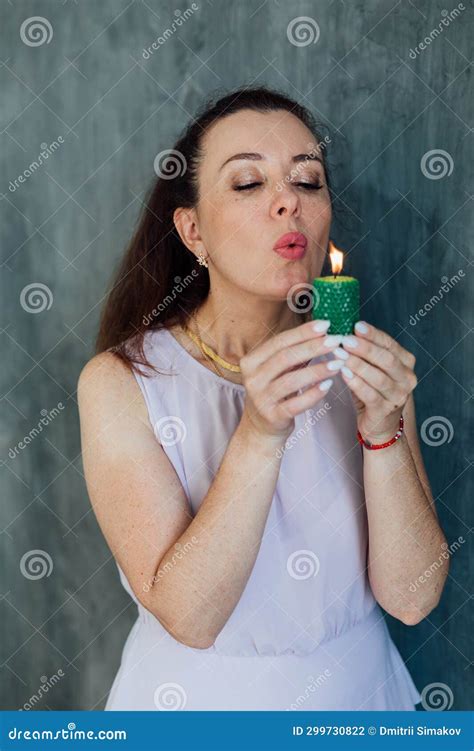 Brunette Woman Blowing Out A Burning Green Candle Stock Photo Image Of Casual Unicorn