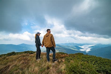 El Hombre Feliz Y Una Mujer De Pie En La Cima De Una Monta A Foto