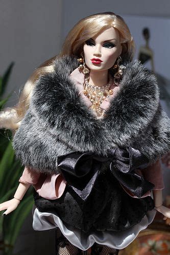 A Barbie Doll Wearing A Black And White Dress With A Fur Stole Around