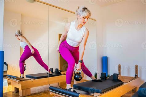 Blonde Woman Is Exercising On Pilates Reformer Bed In Her Home Stock Photo At Vecteezy