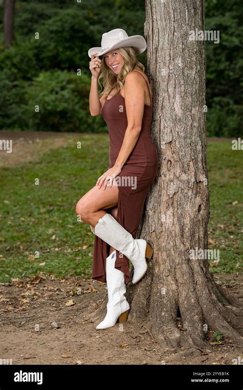 A Stunning Blonde Model Basks In The Late Summer Sun Wearing A Chic Dress White Cowboy Boots