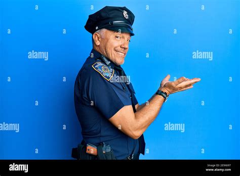 Handsome Middle Age Mature Man Wearing Police Uniform Pointing Aside With Hands Open Palms