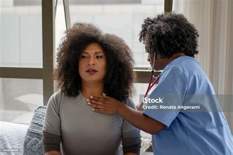 Nurse Examining Transgender Woman At Home Stock Photo Download Image