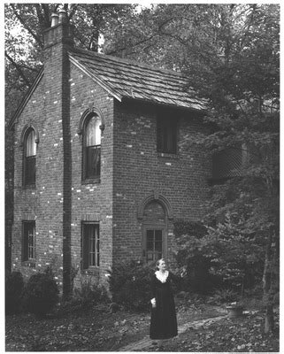 Jean Thomas In Front Of The Wee House In The Woods