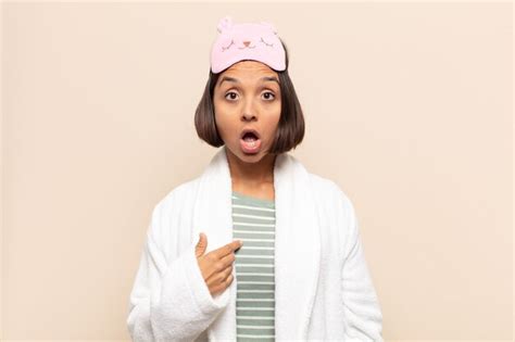 Joven mujer latina mirando consternado y sorprendido con la boca abierta apuntando a sí mismo