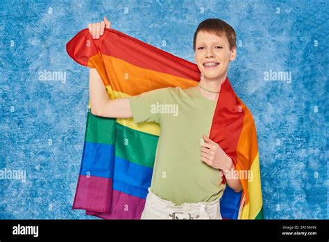 Cheerful Gay Man In Casual Clothes Smiling And Holding Lgbt Flag And