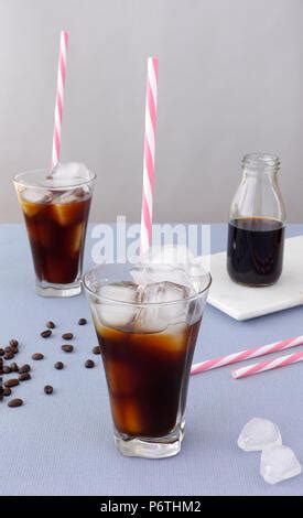 Ein Glas kalten Kaffees mit Eiswürfeln und Spritzern auf dem Tisch