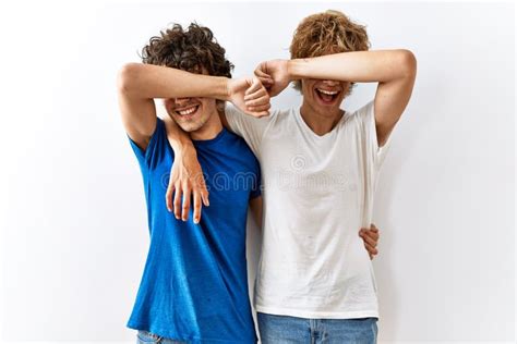 Pareja Joven Gay Parados Juntos En Un Contexto Aislado Sonriendo Alegre Jugando Peek A Boo Con
