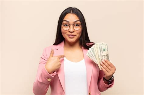 Joven latina que se siente feliz sorprendida y orgullosa señalando a sí misma con una mirada