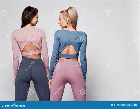Two Sporty Blonde And Brunette Girls In Athletic Body Cloth Sport Wear Cloth Stand Together